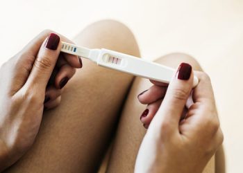 Woman holding a positive pregnancy test