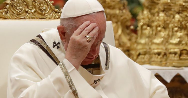 Pope Francis touches his forehead as he celebrates Christmas Eve Mass in St. Peter's Basilica at the Vatican, Tuesday, Dec. 24, 2019. The evening Mass kicks off a busy few days for the pope, commemorating the birth of Christ and the start of a new year. (AP Photo/Alessandra Tarantino)
