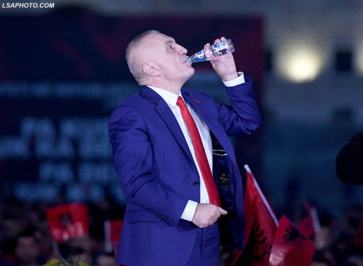 Presidenti, Ilir Meta, duke pire uje ne manifestimin e thirrur prej tij ne Bulevardin "Deshmoret e Kombit", kunder qeverise ne pushtet, ku paralajmeroi se pas 15 marsit, kur te miratohet reforma zgjedhore, do te firmose dekretin per shperndarjen e parlamentit, qe sipas tij eshte ilegjitim. Presidenti Meta, nje ish aleat i koalicionit te Kryeministrit Edi Rama, ka akuzuar kete te fundit per shkelje te kushtetutes dhe perpjekje per te uzurpuar kompetencat e presidentit me qellim kontrollin e emerimeve te gjyqtareve ne gjykaten kushtetuese./r/n/r/nPresident, Ilir Meta, drinks water at an anti-government rally called by him, wherein he announced that after March 15, when the electoral reform is approved, he will sign a decree to dissolve parliament, which is illegitimate, according to him. President Meta, a former coalition ally of Prime Minister Edi Rama has accused the latter of breaching the constitution and trying to usurp the competences of the president with the aim to take control of the appointments of judges in the constitutional court.