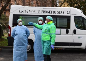 Hospital employees wearing a protection mask and gear work at a temporary emergency structure set up outside the accident and emergency department, where any new arrivals presenting suspect new coronavirus symptoms are being tested, at the Brescia hospital, Lombardy, on March 13, 2020. (Photo by Miguel MEDINA / AFP) (Photo by MIGUEL MEDINA/AFP via Getty Images)