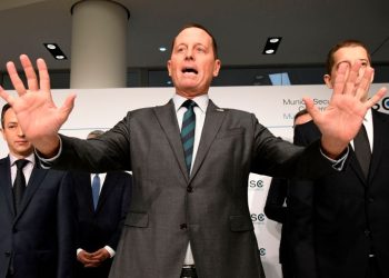 US Ambassador to Germany Richard Grenell (C) gestures during the signing of an agreement between Kosovo and Serbia for railway and street projects at the Munich Security Conference (MSC) in Munich, southern Germany, on February 14, 2020. - The 2020 edition of the Munich Security Conference (MSC) takes place from February 14 to 16, 2020. (Photo by THOMAS KIENZLE / AFP) (Photo by THOMAS KIENZLE/AFP via Getty Images)