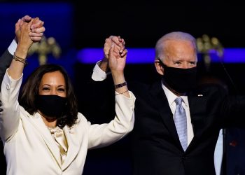 Vice President-elect Kamala Harris holds hands with President-elect Joe Biden and her husband Doug Emhoff as they celebrate Saturday, Nov. 7, 2020, in Wilmington, Del. (AP Photo/Andrew Harnik)
