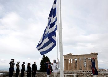 Members of the Presidential Guard raise the Greek flag in front of the Parthenon temple atop the Acropolis during celebrations of the 200th anniversary of the Greek War of Independence as Greek Prime Minister Kyriakos Mitsotakis and Greek President Katerina Sakellaropoulou attend the ceremony in Athens, Greece, March 25, 2021. Alexandros Vlachos/Pool via REUTERS
