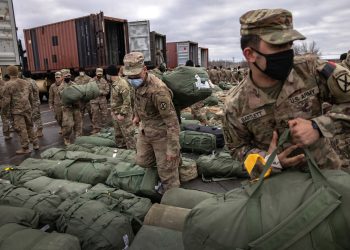 FORT DRUM, NEW YORK - DECEMBER 10: U.S. Army soldiers retrieve their duffel bags after they returned home from a 9-month deployment to Afghanistan on December 10, 2020 at Fort Drum, New York. The 10th Mountain Division soldiers who arrived this week are under orders to isolate with family at home or with fellow troops in barracks, finishing their quarantine just before Christmas. In the waning days of the Trump Administration and after 19 years of war, the U.S. military continues to reduce troop levels in Afghanistan.  (Photo by John Moore/Getty Images)