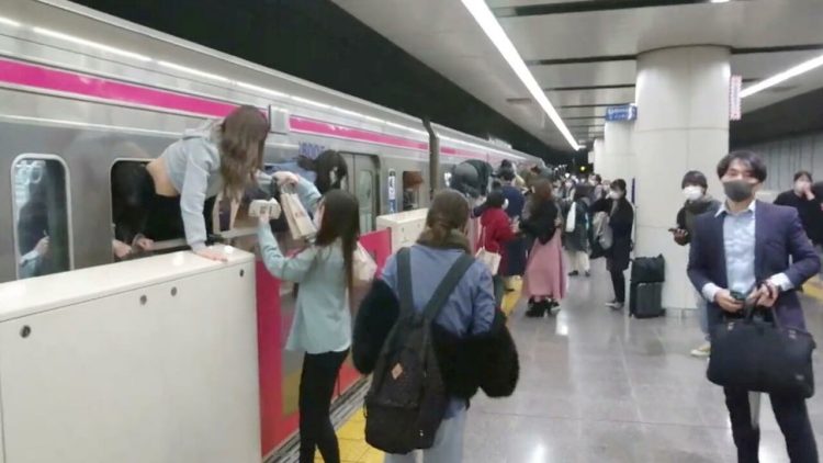 People escape through windows of a Tokyo train line following a knife, arson and acid attack, in Tokyo, Japan October 31, 2021 in this still image obtained from a social media video. TWITTER / @SIZ33/via REUTERS THIS IMAGE HAS BEEN SUPPLIED BY A THIRD PARTY. MANDATORY CREDIT. NO RESALES. NO ARCHIVES.