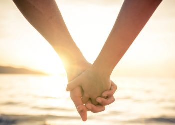 Couple of lovers holding their hands at a beautiful sunset over the ocean - Newlywed couple on a romantic vacation; Shutterstock ID 280073369