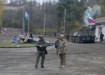 An Azerbaijani service member and a Russian peacekeeper stand guard at a checkpoint on the outskirts of Shusha (Shushi) in the region of Nagorno-Karabakh, November 13, 2020. REUTERS/Stringer