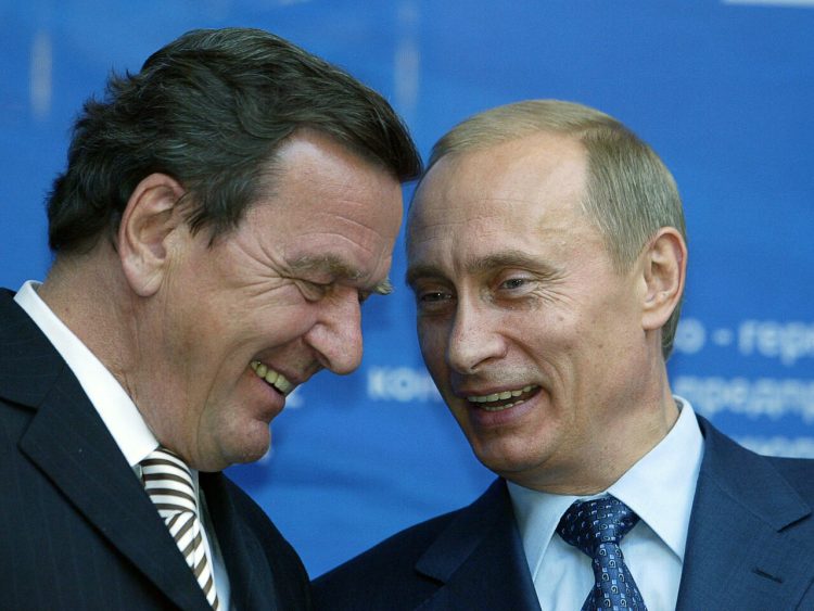 (FILES) This file photo taken on July 8, 2004 shows then Russian President Vladimir Putin (R) and then German Chancellor Gerhard Schroeder sharing a smile while they take part in the Russian-German economic forum in Moscow. - Former German chancellor Gerhard Schroeder's close friendship with President Vladimir Putin and lucrative business dealings with Russia have for years been reluctantly tolerated at home. But as war clouds gather over Ukraine and allies question Germany's resolve, Schroeder is increasingly seen as potential liability to new chancellor and fellow Social Democrat Olaf Scholz, fuelling calls for a clean break with the pro-Kremlin lobbyist. (Photo by MAXIM MARMUR / AFP)