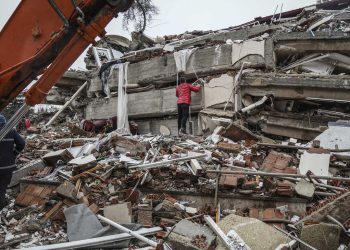 A man searches for people  in the rubble of a destroyed building in Gaziantep, Turkey, Monday, Feb. 6, 2023. A powerful quake has knocked down multiple buildings in southeast Turkey and Syria and many casualties are feared. (AP Photo/Mustafa Karali)