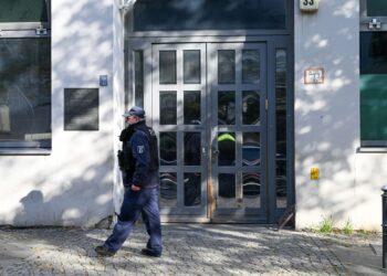 18 October 2023, Berlin: A Police officers walks in front of Berlin's Jewish community centre and synagogue after it was struck with two homemade incendiary devices in a suspected arson assault, causing horror and outrage among the Jewish community in the German capital. Photo: Soeren Stache/dpa