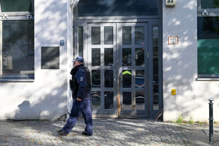 18 October 2023, Berlin: A Police officers walks in front of Berlin's Jewish community centre and synagogue after it was struck with two homemade incendiary devices in a suspected arson assault, causing horror and outrage among the Jewish community in the German capital. Photo: Soeren Stache/dpa