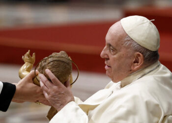 Pope Francis holds a statue of Baby Jesus during the Christmas Eve mass in St. Peter's Basilica at the Vatican, December 24, 2022. REUTERS/Guglielmo Mangiapane