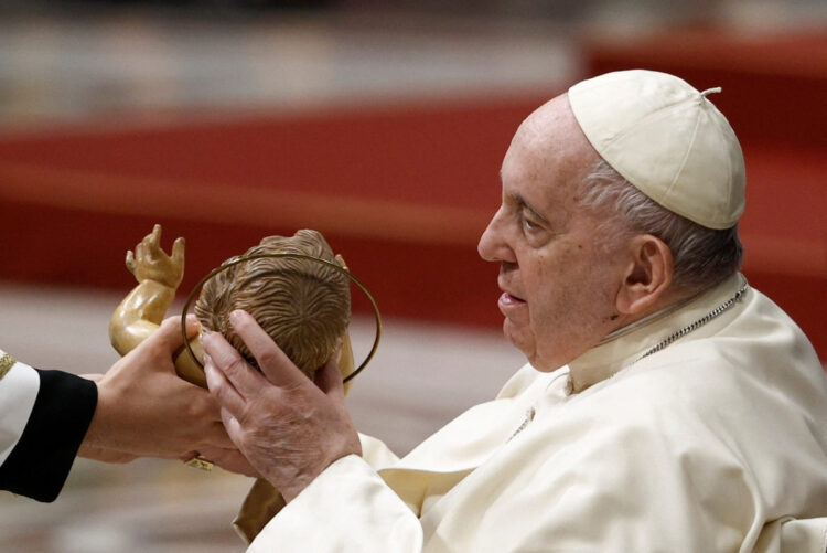 Pope Francis holds a statue of Baby Jesus during the Christmas Eve mass in St. Peter's Basilica at the Vatican, December 24, 2022. REUTERS/Guglielmo Mangiapane
