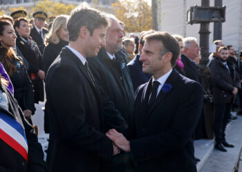 French President Emmanuel Macron (R) shakes hands with French Education and Youth Minister Gabriel Attal (L) during a ceremony at the Tomb of the Unknown Soldier at the Arc de Triomphe in Paris on November 11, 2023, as part of commemorations marking the 105th anniversary of the November 11, 1918 Armistice, ending World War I (WWI). (Photo by Ludovic MARIN / POOL / AFP) (Photo by LUDOVIC MARIN/POOL/AFP via Getty Images)