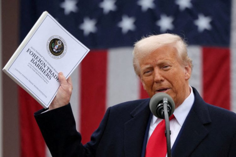 FILE PHOTO: U.S. President Donald Trump holds a "Foreign Trade Barriers" document as he delivers remarks on tariffs in the Rose Garden at the White House in Washington, D.C., U.S., April 2, 2025. REUTERS/Carlos Barria TPX IMAGES OF THE DAY/File Photo