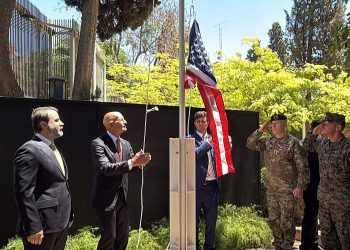 Syrian Foreign Minister Assaad al-Shibani (L) looks on as US special envoy for Syria, the ambassador to Turkey Thomas Barrack, raises the flag of the United States at the US ambassador's residence in Damascus during an official ceremony held on May 29, 2025. Barrack's visit to Syria marks a new step in the rapprochement between the two countries following the fall of former president Bashar al-Assad.  The US embassy in Syria has been closed since Assad's crackdown on an anti-government uprising that broke out in 2011 and then spiraled into civil war until 2024. (Photo by Rami al SAYED / AFP) (Photo by RAMI AL SAYED/AFP via Getty Images)