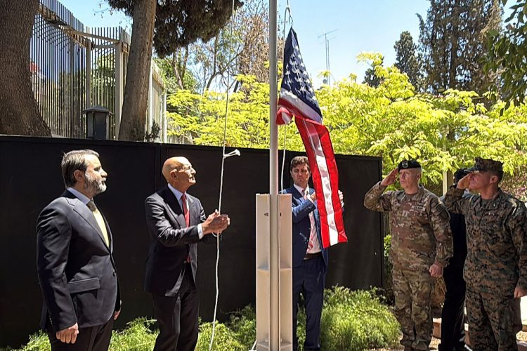 Syrian Foreign Minister Assaad al-Shibani (L) looks on as US special envoy for Syria, the ambassador to Turkey Thomas Barrack, raises the flag of the United States at the US ambassador's residence in Damascus during an official ceremony held on May 29, 2025. Barrack's visit to Syria marks a new step in the rapprochement between the two countries following the fall of former president Bashar al-Assad.  The US embassy in Syria has been closed since Assad's crackdown on an anti-government uprising that broke out in 2011 and then spiraled into civil war until 2024. (Photo by Rami al SAYED / AFP) (Photo by RAMI AL SAYED/AFP via Getty Images)