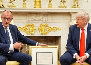 German Chancellor Friedrich Merz gives US President Donald Trump a present of a facsimile of the birth certificate of Friedrich (later Frederick) Trump, grandfather of US President Donald Trump, in the Oval Office of the White House in Washington, DC, on June 5, 2025. Chancellor Merz and US President Trump meet for talks at the White House, with the Ukraine and Mideast conflicts on the agenda along with rocky trade relations. The talks mark Merz's first official visit as chancellor since taking office in early May, and are the first time the two leaders meet. (Photo by Michael Kappeler / POOL / AFP)