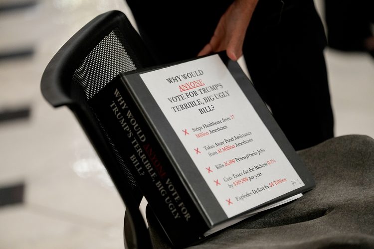 Representative Madeleine Dean, a Democrat from Pennsylvania, reaches for a binder during a television interview at the US Capitol in Washington, DC, US, on Wednesday, July 2, 2025. Donald Trump's multitrillion-dollar tax bill is running into Republican resistance in the House as moderate and ultraconservative GOP lawmakers threaten to defy the president and sink his domestic agenda. Photographer: Kent Nishimura/Bloomberg