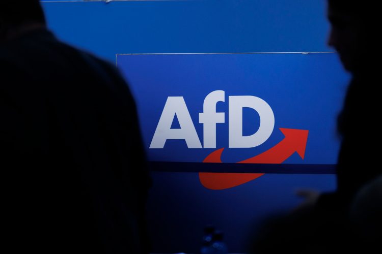 FILED - 28 July 2023, Saxony-Anhalt, Magdeburg: People walk in front of the party logo at the Alternative for Germany (AfD) party conference in Magdeburg. Photo: Carsten Koall/dpa