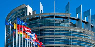 The European Parliament building in Strasbourg, France with flags waving calmly celebrating peace of the Europe. July 12, 2020.