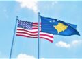 Kosovo and USA, two flags waving against blue sky. 3d image