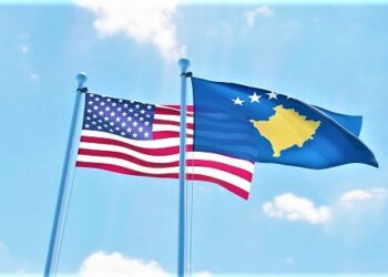 Kosovo and USA, two flags waving against blue sky. 3d image