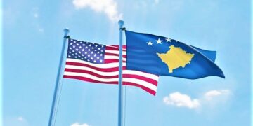 Kosovo and USA, two flags waving against blue sky. 3d image