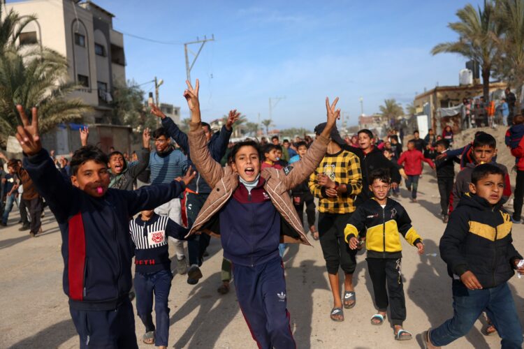 TOPSHOT - Children cheer in Nuseirat in the central Gaza Strip on January 19, 2025, shortly before a ceasefire deal in the war between Israel and the Palestinian militant group Hamas was implemented. (Photo by Bashar TALEB / AFP) (Photo by BASHAR TALEB/AFP via Getty Images)