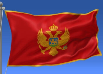 Montenegro flag waving on the flagpole on a sky background