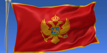 Montenegro flag waving on the flagpole on a sky background